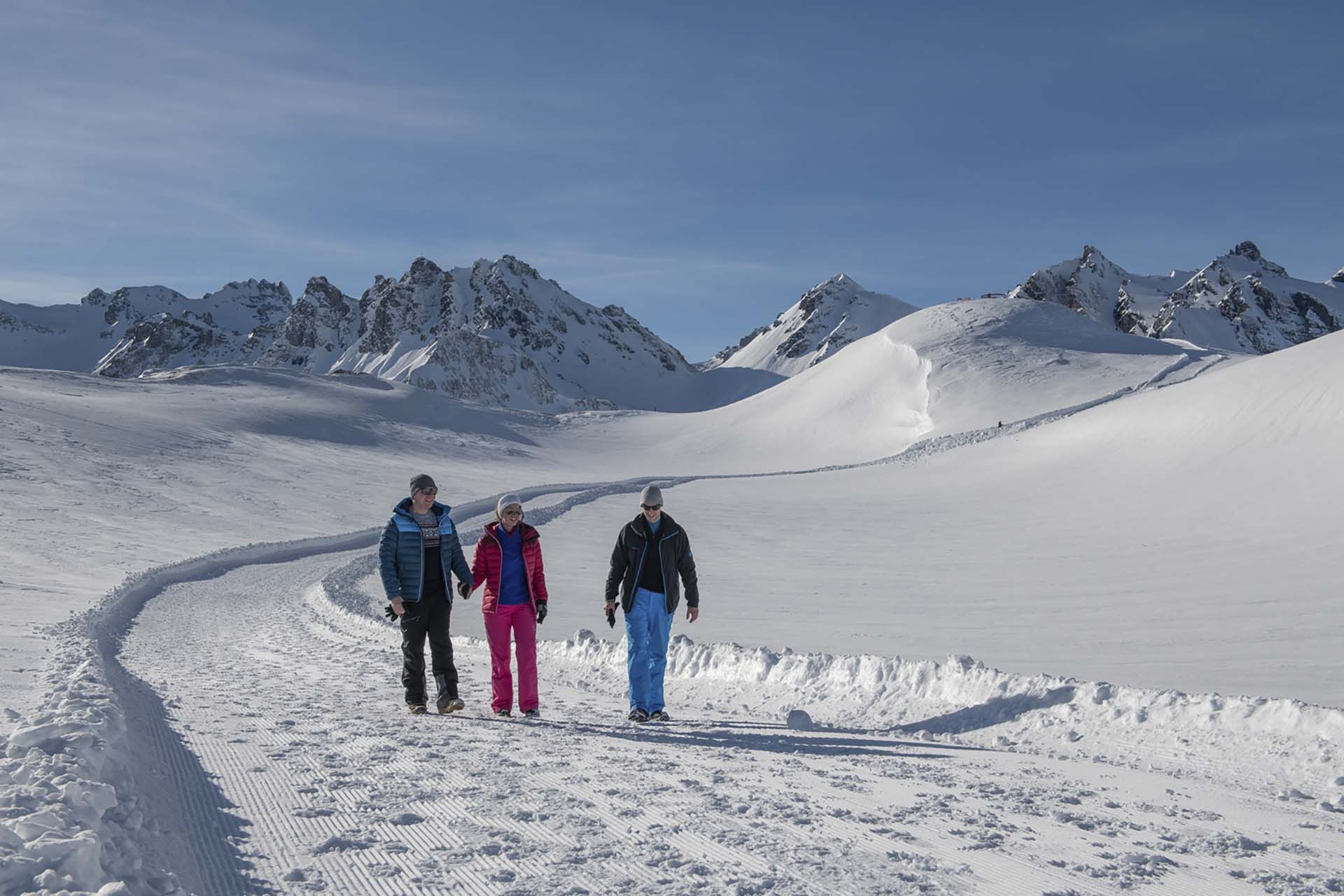 Drei Personen geniessen winterliches Wandern im Schnee im Pizol